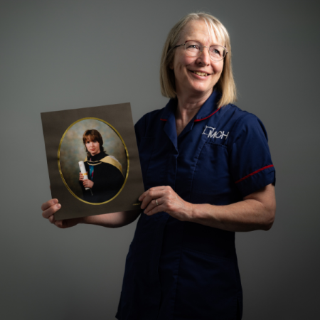 Occupational therapist holding a photo of her graduation photo
